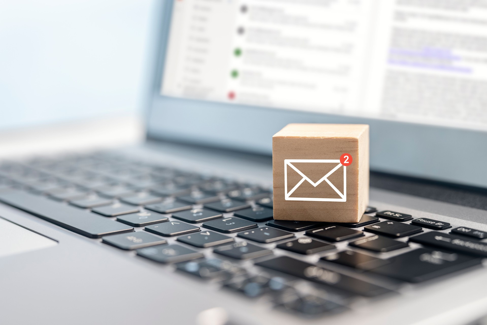 New email symbol on wooden block on laptop keyboard